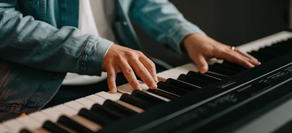 A man playing chord shapes on piano